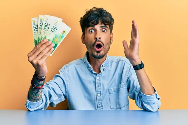 Masada oturan İspanyol asıllı genç adam korkmuş ve şaşırmış bir şekilde şaşkınlık içinde şaşkınlık içinde, inançsız bir yüz ifadesi takınıyordu. 