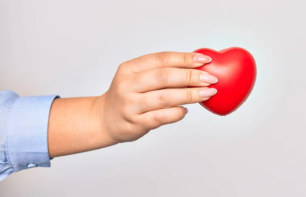 Mão Caucasiano Jovem Segurando Coração Vermelho Sobre Fundo Branco Isolado — Fotografia de Stock