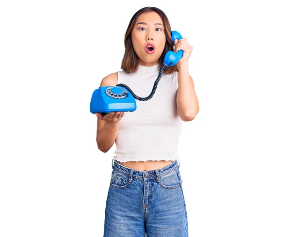 Young Beautiful Chinese Girl Holding Vintage Telephone Scared Amazed Open — Stock Photo, Image