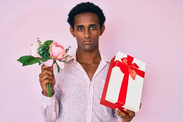 Afrykański Przystojny Mężczyzna Trzyma Prezent Rocznicowy Bukiet Kwiatów Zrelaksowany Poważnym — Zdjęcie stockowe