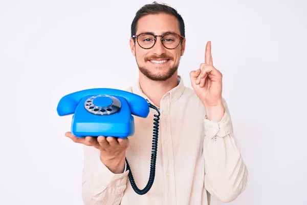 Junger Gutaussehender Mann Mit Oldtimer Telefon Überrascht Mit Einer Idee — Stockfoto