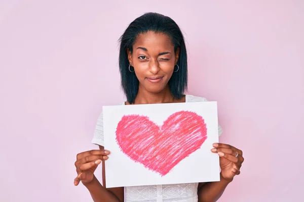 Young African American Woman Holding Heart Draw Winking Looking Camera — Stock Photo, Image