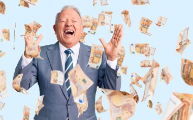 Kıdemli, gri saçlı, zarif takım elbiseli, çılgın ve çılgın başarısını kutlayan, kolları havada, gözleri kapalı, heyecanlı bir adam. Kazanan konsept