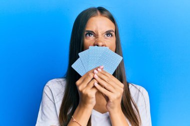 Genç İspanyol kadın poker oynuyor, yüzünü kartlarla kapatıyor kızgın ve kızgın çığlıklar atıyor, öfkeyle bağırıyor, öfkeyle yukarı bakıyor.. 