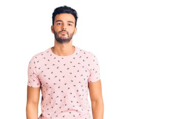 Yüzünde ciddi bir ifade olan gündelik kıyafetler giyen yakışıklı İspanyol bir adam. Basit ve doğal bir şekilde kameraya bakıyorsun.. 