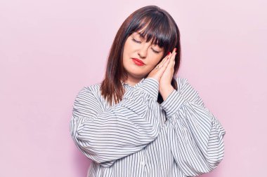 Genç ve cüsseli bir kadın rahat kıyafetler giyer, uyur, yorgun düşler görür ve elleri ile poz verir, gözleri kapalı gülümserdi.. 