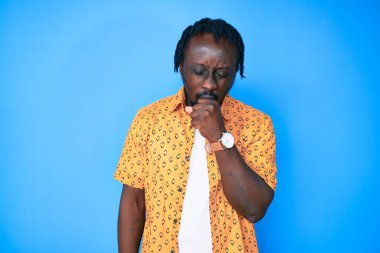 Örgülü, sıradan kıyafetler giyen, kendini kötü hisseden ve soğuk algınlığı veya bronşitin belirtisi olarak öksüren Afrikalı genç bir Amerikalı. sağlık hizmeti kavramı. 