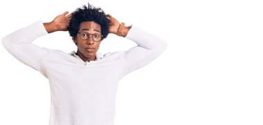 Afro saçlı, sıradan giyinmiş, gözlüklü, tavşan kulaklı, avuç içi hareketleriyle kuşkucu ve şüpheci görünen yakışıklı Afro-Amerikan bir adam. Paskalya tavşanı konsepti. 