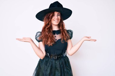 Cadılar Bayramı kostümü giymiş genç ve güzel bir kadın gülümsüyor. İki elini de açık tutuyor. Karşılaştırma ve reklam karşılaştırması yapıyor ve dengeyi sağlıyor. 