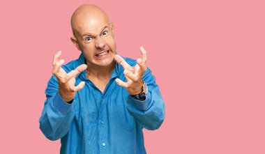 Orta yaşlı, kel bir adam, günlük giysiler içinde öfkeyle bağırıyor, elleri boğazlamaya çalışıyor, deli gibi bağırıyor. 