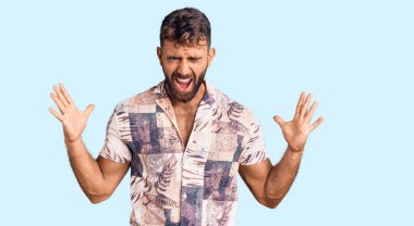 Yaz kıyafetleri giymiş genç İspanyol adam başarı için deli ve çılgınlığı kutluyor kollarını kaldırmış ve gözlerini kapatmış heyecanla bağırıyor. Kazanan konsept 