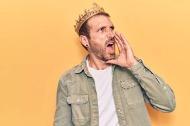 Kral tacını takmış genç yakışıklı adam el ele verip bağırıyor ve bağırıyor. iletişim konsepti. 