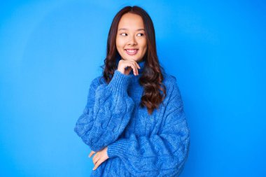 Genç, güzel, Çinli bir kız. Elleri çenesinde, sıradan bir kazak giyiyor. Soru sormayı düşünüyor. Düşünceli bir yüzle gülümsüyor. şüphe kavramı. 