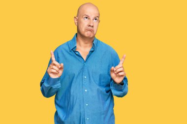 Orta yaşlı, kel bir adam üzgün ve üzgün görünüyor. Mutsuz ve depresif görünüyor.. 