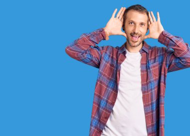 Gündelik kıyafetler giyen, neşeli gülücükler saçan genç yakışıklı bir adam ellerini göstererek bir yuhalamaya bakıyor. Şaşırdım ve çıktım. 