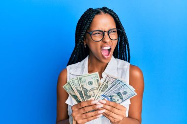 Dolarları tutan güzel İspanyol kadın kızgın ve kızgın çığlıklar atıyor öfkeyle bağırıyor. öfke ve agresif konsept. 