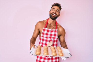İspanyol asıllı genç üstsüz fırıncı üniforması giymiş ev yapımı ekmek tutuyor ve kahkahalarla gülüyor çünkü komik, çılgınca bir şaka.. 