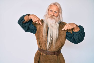 Gri saçlı, uzun sakallı, Viking kostümü giyen, kendine güveni olan, kendini gururlu ve mutlu gösteren yaşlı bir adam.. 