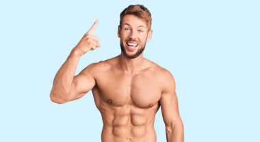 Kafkasyalı genç adam tişörtsüz, başarılı bir fikirle parmakla işaret ediyor. Heyecanlı ve mutlu. Bir numara.. 