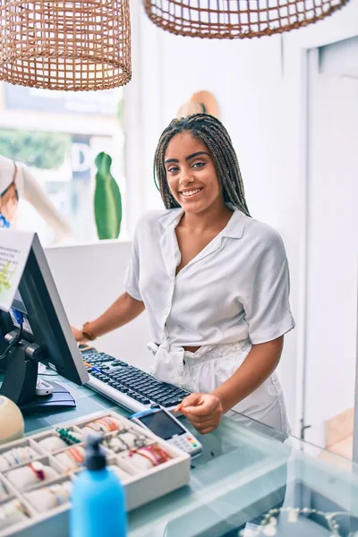 年轻的非洲裔美国女人开心地笑着在零售店的柜台边干活 — 图库照片