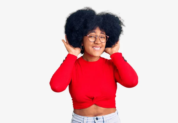 若いアフリカ系アメリカ人の少女のカジュアルな服や眼鏡を耳のジェスチャーで両方の手を聞くしようとすると ゴシップを好奇心を着て 聴覚障害や聴覚障害 — ストック写真