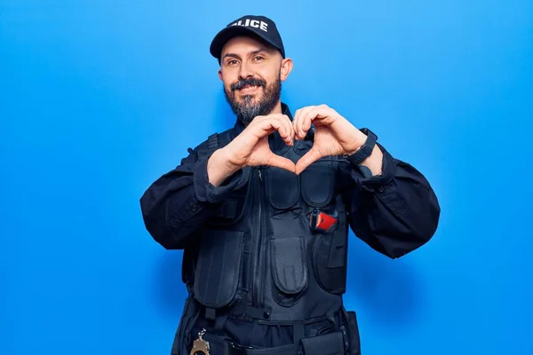 Mladý Pohledný Muž Policejní Uniformě Usmívající Lásce Ukazuje Symbol Srdce — Stock fotografie