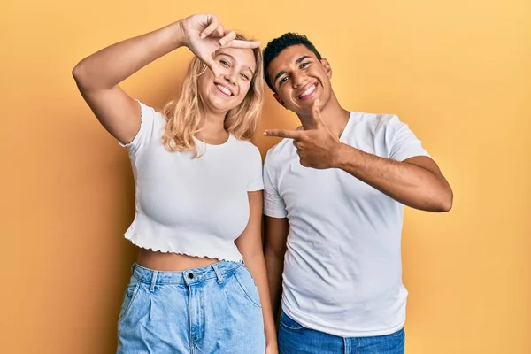 Młoda Para Międzyrasowa Ubrana Luźną Białą Koszulkę Uśmiechnięta Ramki Dłońmi — Zdjęcie stockowe