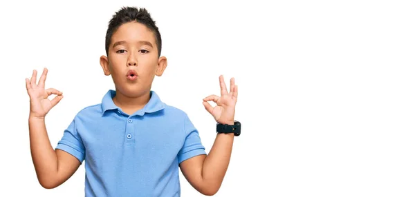 カジュアルな服を着ている小さな男の子のヒスパニック系の子供は驚いており 指でOk承認シンボルをやってショックを受けました クレイジーな表現 — ストック写真