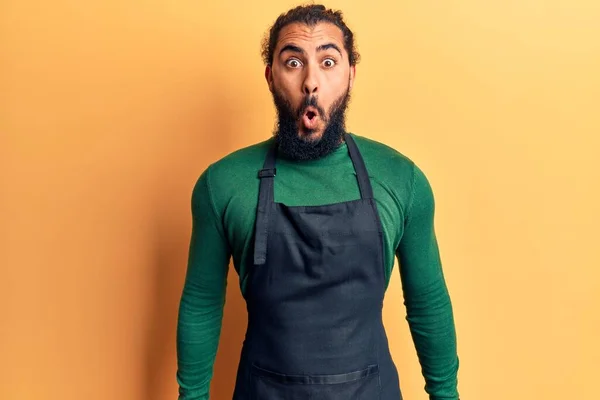 床屋のエプロンを身に着けている若いアラブ人男性は怖がって 驚きのために口を開けて驚いて 不信の顔 — ストック写真