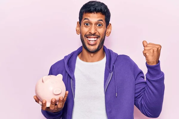 Jovem Latino Segurando Porquinho Banco Gritando Orgulhoso Celebrando Vitória Sucesso — Fotografia de Stock