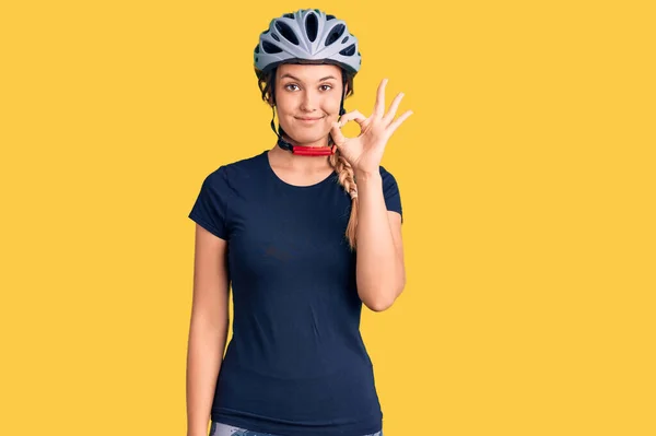 Beautiful caucasian woman wearing bike helmet smiling positive doing ok sign with hand and fingers. successful expression.