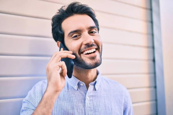 Jovem Hispânico Homem Sorrindo Feliz Falando Smartphone Inclinado Parede — Fotografia de Stock