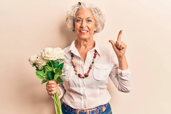 Elinde Çiçeklerle Gülümseyen Yaşlı Gri Saçlı Kadın Bir Fikir Veya — Stok fotoğraf