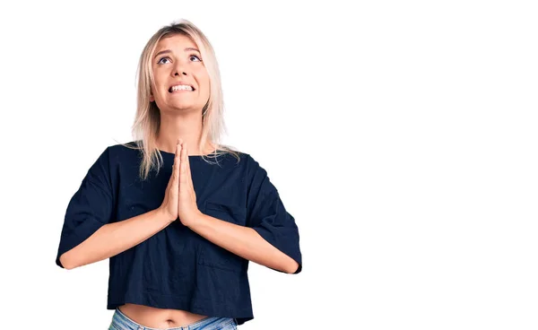 Νέα Όμορφη Ξανθιά Γυναίκα Φορώντας Casual Shirt Επαιτεία Και Προσεύχεται — Φωτογραφία Αρχείου