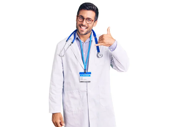 Jovem Hispânico Vestindo Uniforme Médico Estetoscópio Sorrindo Fazendo Gesto Telefone — Fotografia de Stock