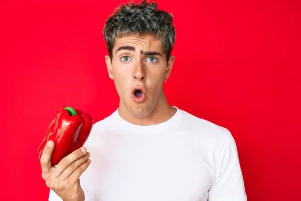 Young Handsome Man Holding Red Pepper Scared Amazed Open Mouth — Stock Photo, Image