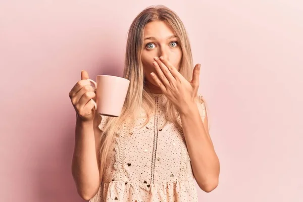 Jovem Bela Mulher Loira Segurando Café Cobrindo Boca Com Mão — Fotografia de Stock