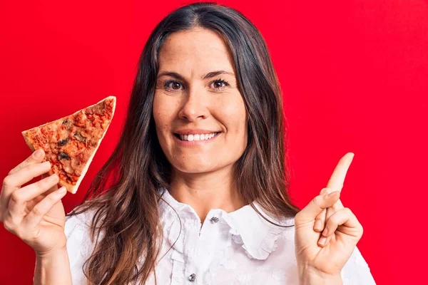 Молодая Красивая Брюнетка Женщина Ест Кусочек Итальянской Пиццы Изолированном Красном — стоковое фото