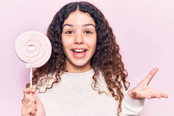 Güzel Kız Kıvırcık Saçlı Lolipop Tutan Mutlu Bir Gülümsemeyle Başarıyı — Stok fotoğraf