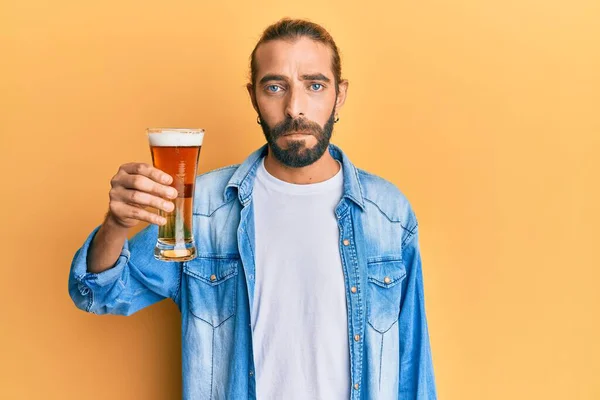 有魅力的长发大胡子的男人喝着一品脱啤酒 思维端庄 表情沉着 看起来很自信 — 图库照片