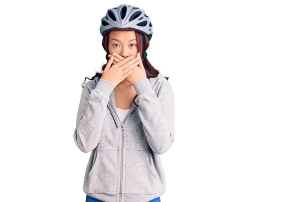 若い美しい中国の女の子は間違いのための手で口をカバーショックを受けた自転車のヘルメットを着て 秘密の概念 — ストック写真