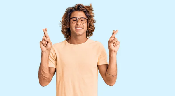 Jovem Hispânico Vestindo Roupas Casuais Óculos Gesticulando Dedo Cruzado Sorrindo — Fotografia de Stock