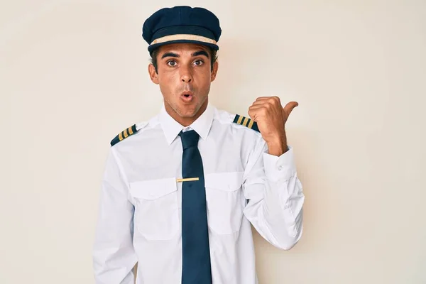 Junger Hispanischer Mann Flugzeugpilotenuniform Überrascht Zeigt Mit Dem Finger Zur — Stockfoto