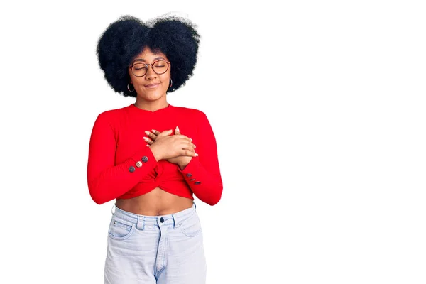 年轻的非洲裔美国女孩 身穿休闲装 戴着眼镜 双手放在胸前笑着 闭着眼睛 脸上挂着感激的手势 健康概念 — 图库照片