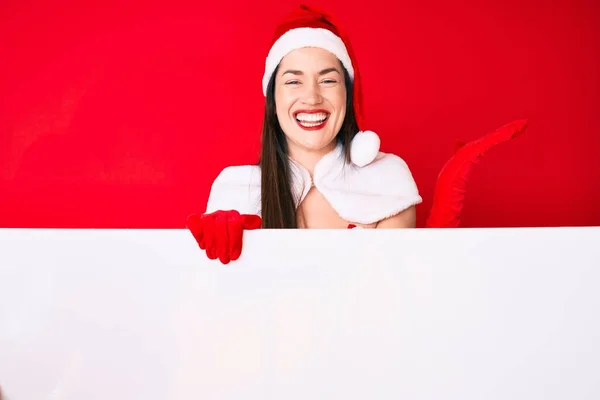 Young Woman Wearing Santa Claus Costume Holding Blank Empty Banner — Stock Photo, Image