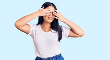 Genç ve güzel Asyalı kız günlük kıyafetler ve gözlük takıyor. Gözleri kapatıyordu. Neşeli ve komik gülümsüyordu. kör kavram. 