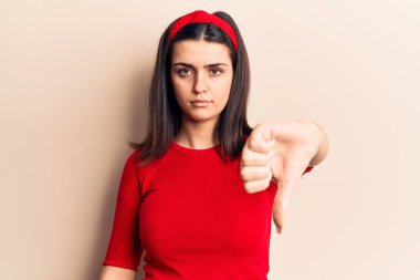 Gündelik tişört ve diyabet giyen genç ve güzel bir kız mutsuz ve kızgın görünüyor. Reddedilmiş ve olumsuz hareketler yapıyor. kötü ifade. 