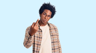 Handsome african american man with afro hair wearing casual clothes and glasses showing middle finger, impolite and rude fuck off expression 
