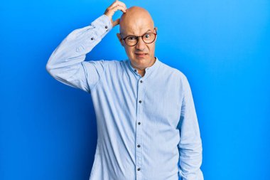 Gündelik kıyafet ve gözlük takan orta yaşlı kel bir adam soru sormayı merak ediyor. Şüpheyle kararsız, kafa kafaya düşünerek. Düşünceli kavram. 