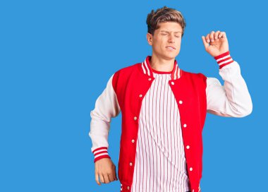 Beyzbol üniforması giyen genç, yorgun ve rahat, uykulu ve sabahın erken saatleri için esniyor. 